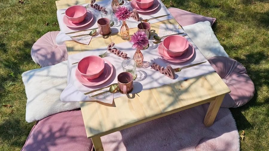 Lage picknicktafel in de tuin met kussens