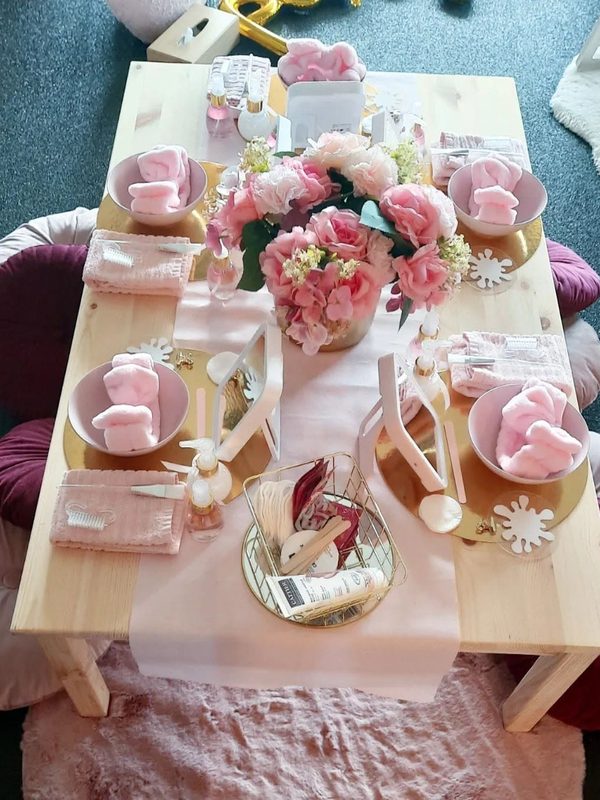 Feestelijke tafel met bloemen en roze bordjes