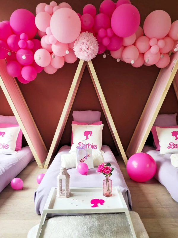 Roze tentjes met ballonnenboog en Barbie-kussens